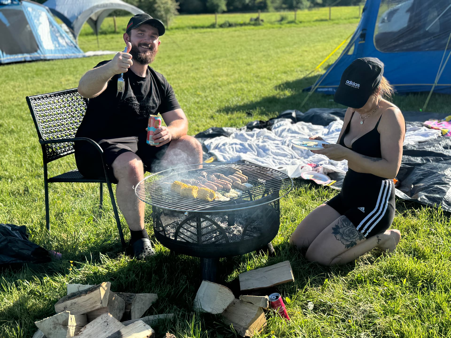 Campers cooking on a firepit grill