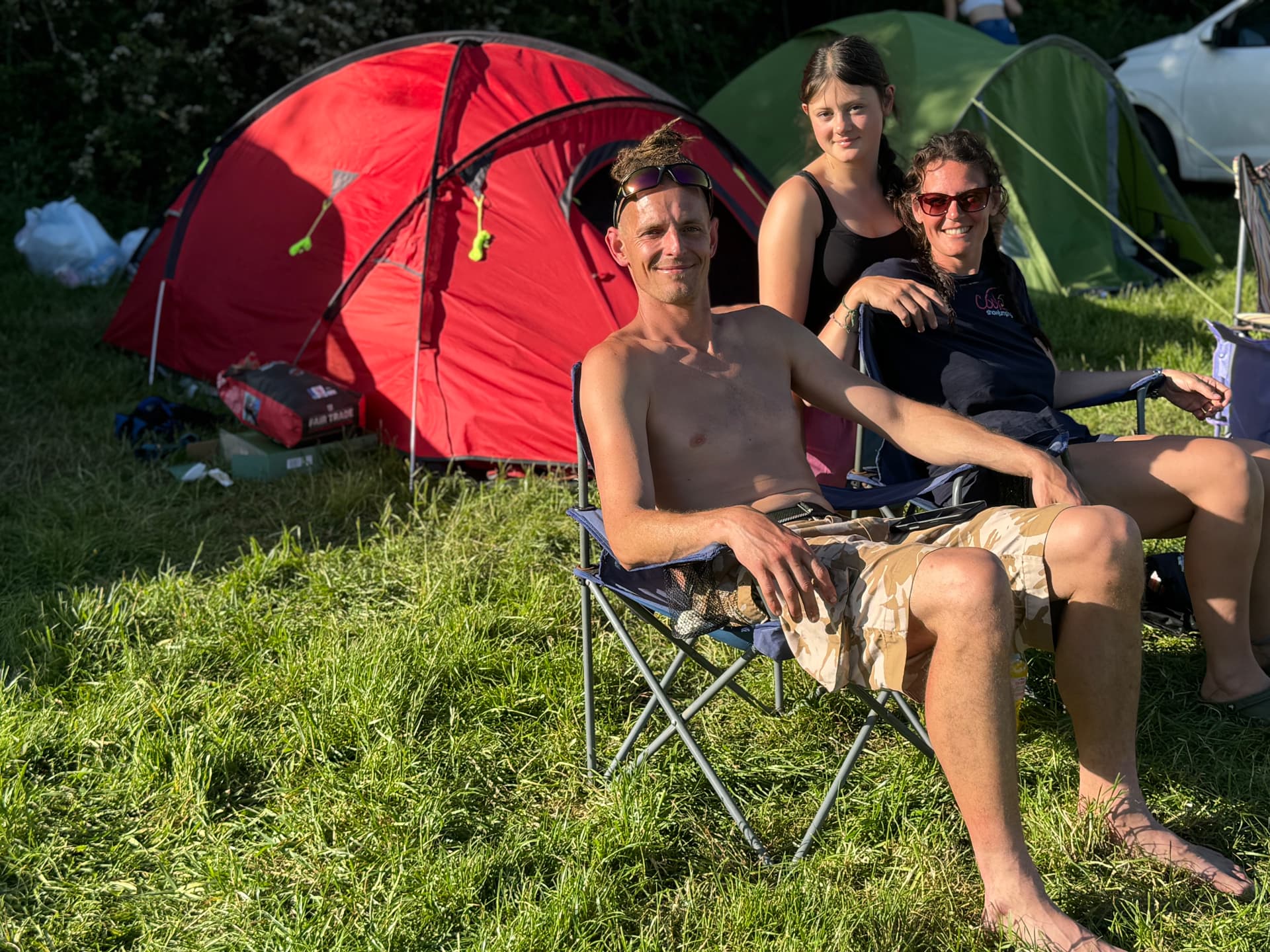 A family relaxing beside their tents